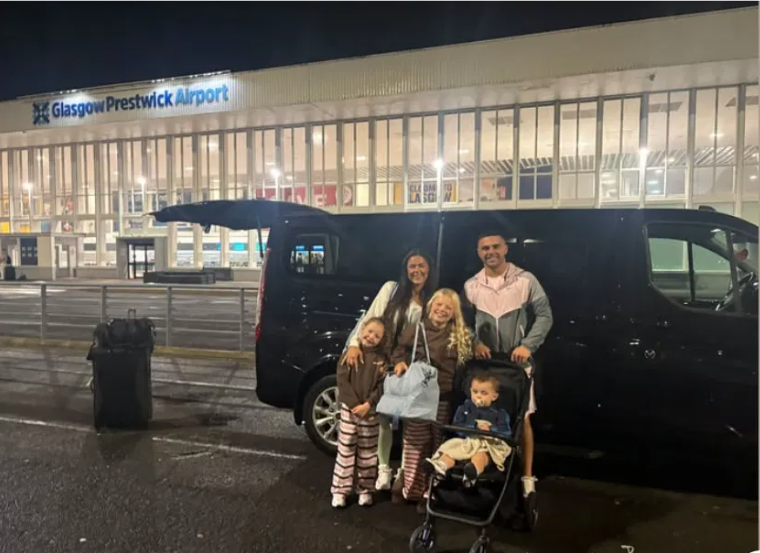 Family beside the B&J Elite Travel minibus at Glasgow Prestwick Airport